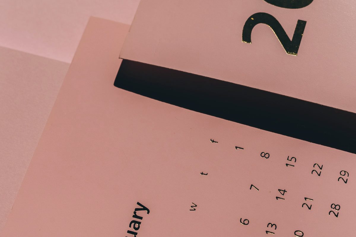 Modern paper calendars with weekly dates on desk