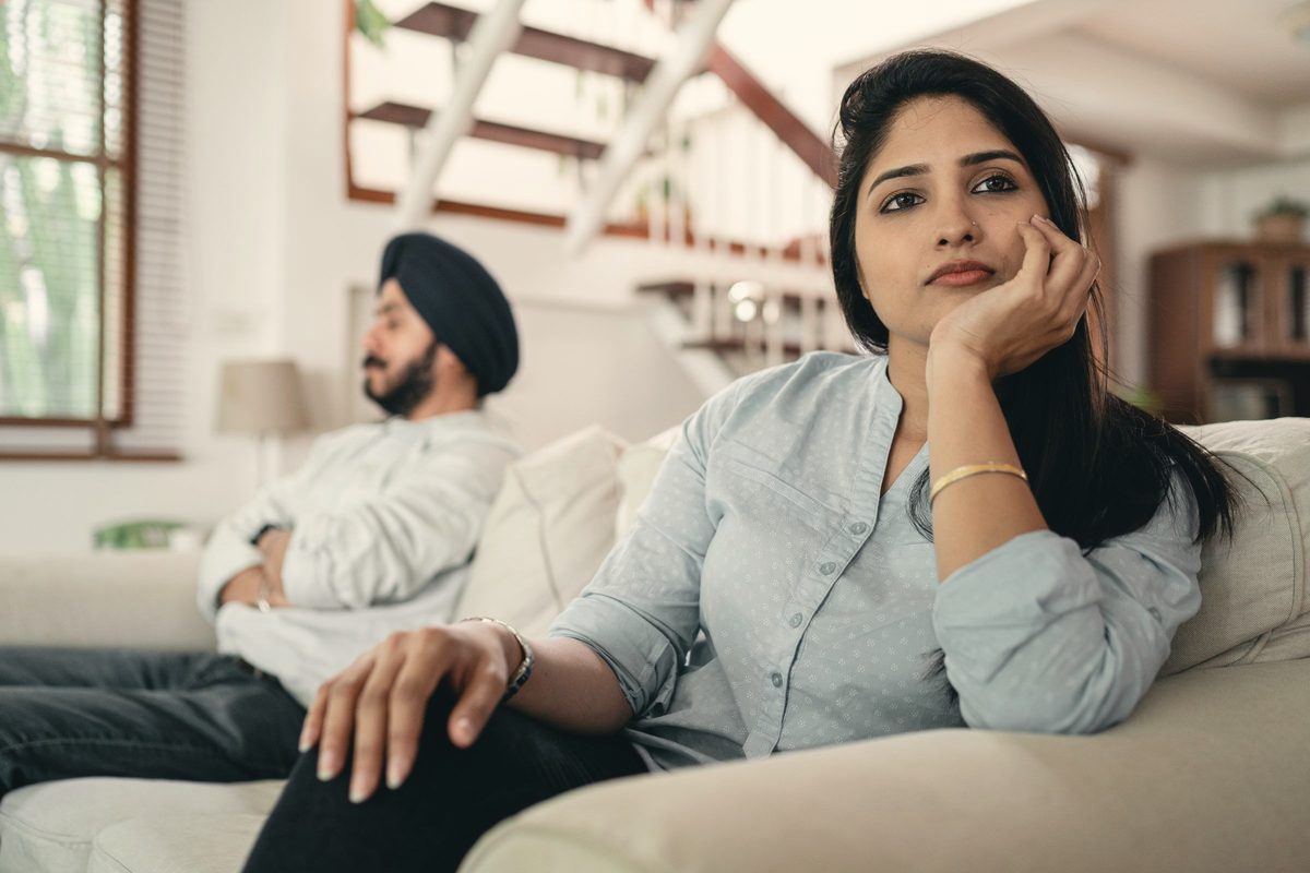 Couple sitting apart on a sofa after a disagreement