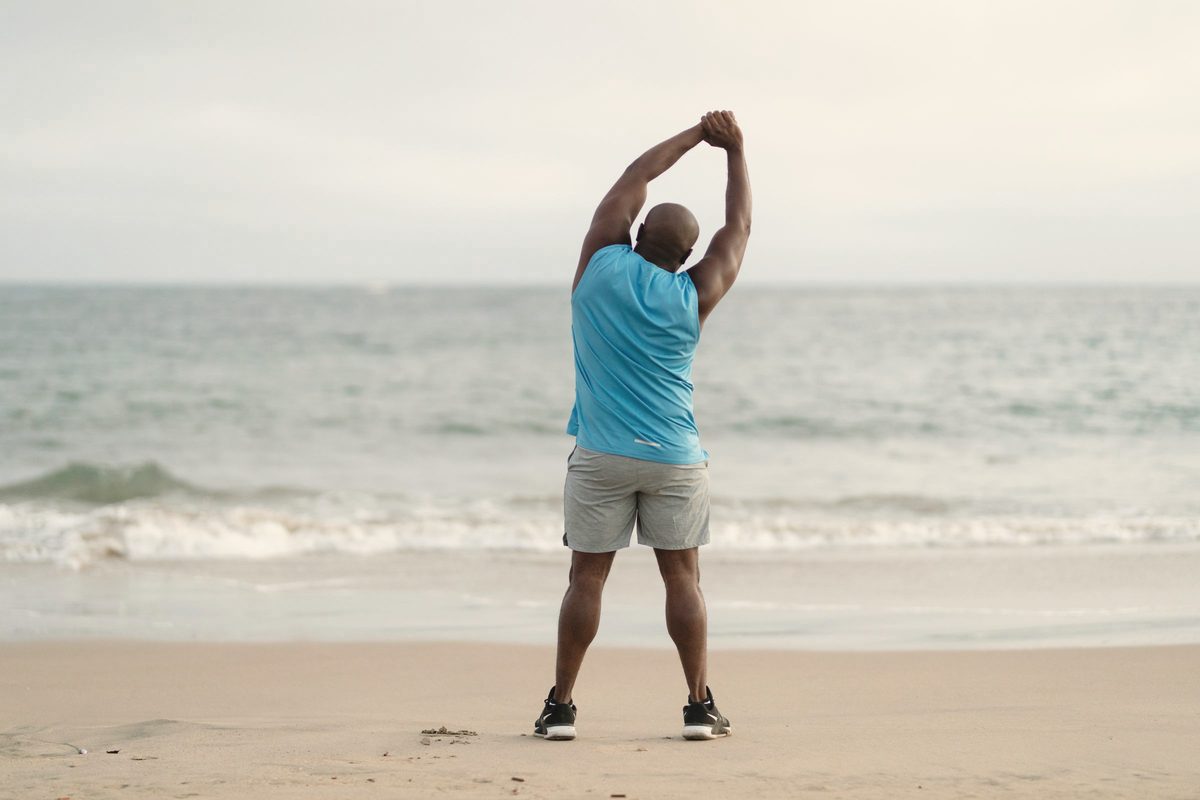 Man stretching on the beach