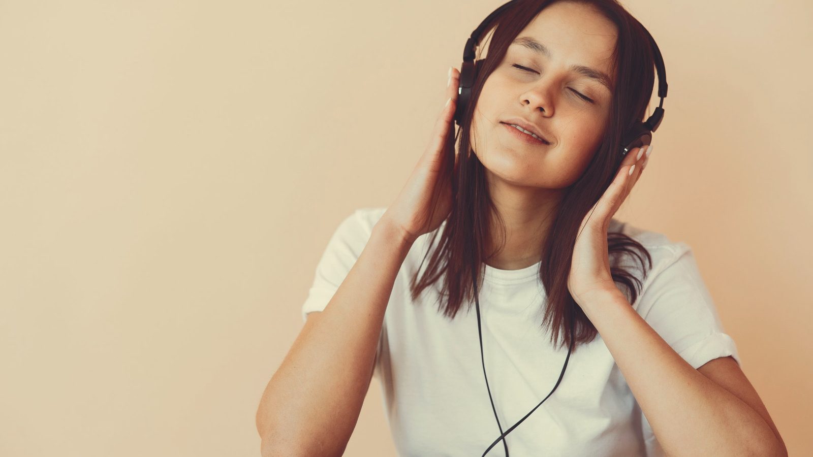 Relaxed woman listening to music through headphones