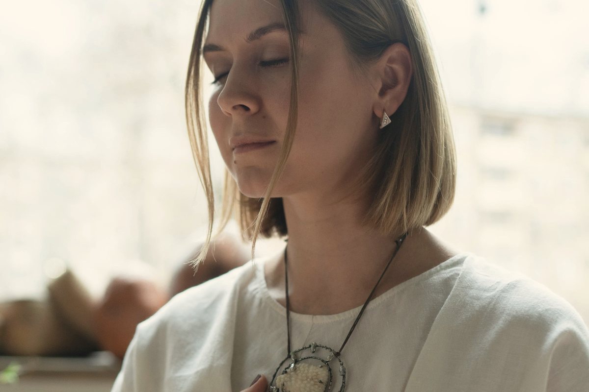 Woman with eyes closed and a hand on her chest during a breathing exercise