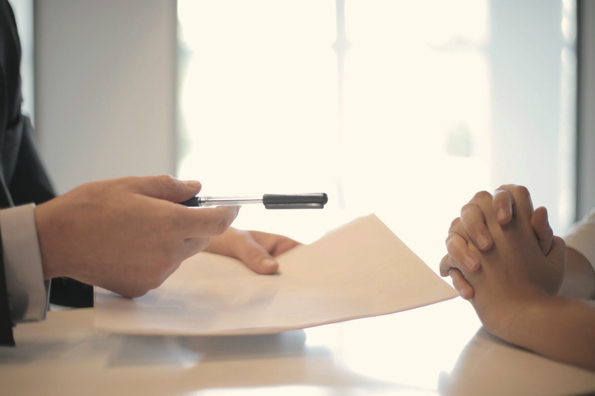 Hands reviewing a printed document across a desk during a clinical discussion