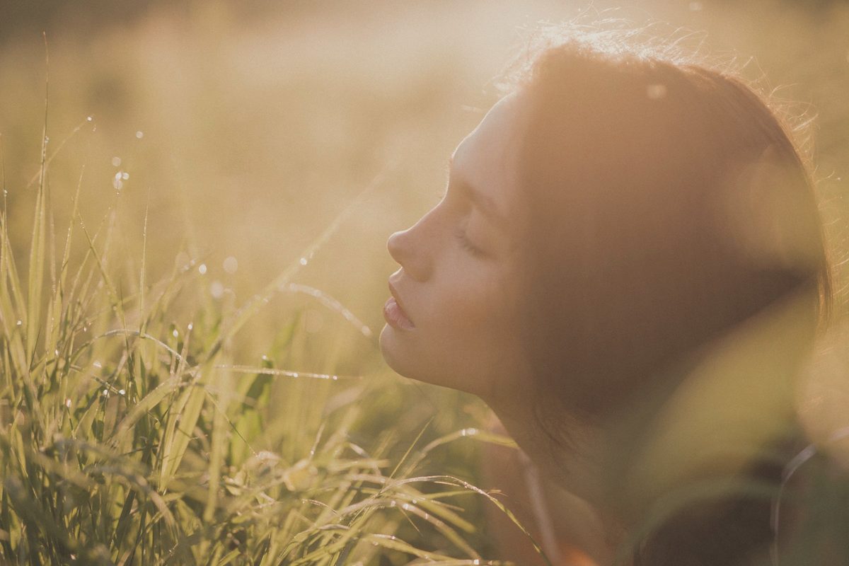 Woman with her eyes closed in warm sunlight