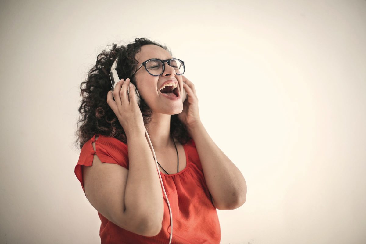 Woman singing along to music on her headphones