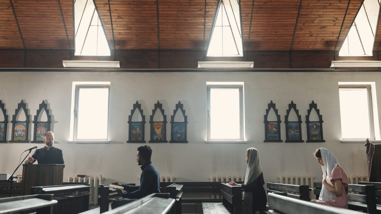 People sitting on benches in church while praying