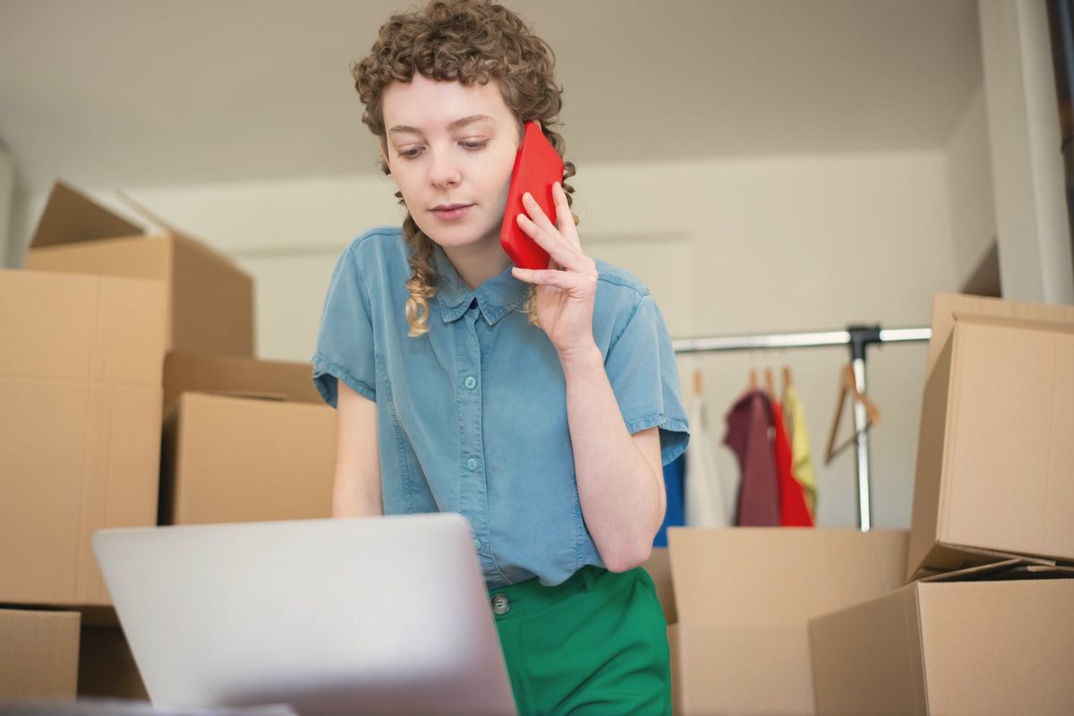 Woman on a phone call while looking at her laptop