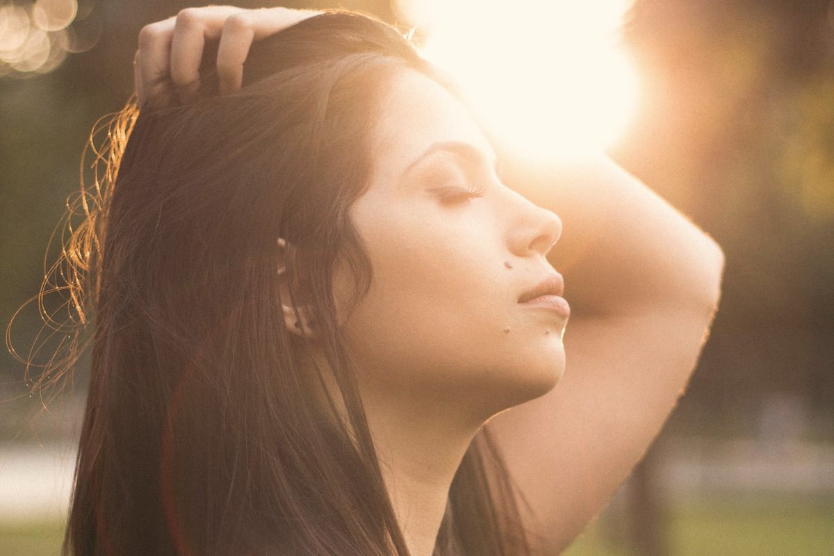 Woman with her eyes closed as sunlight shines on her face