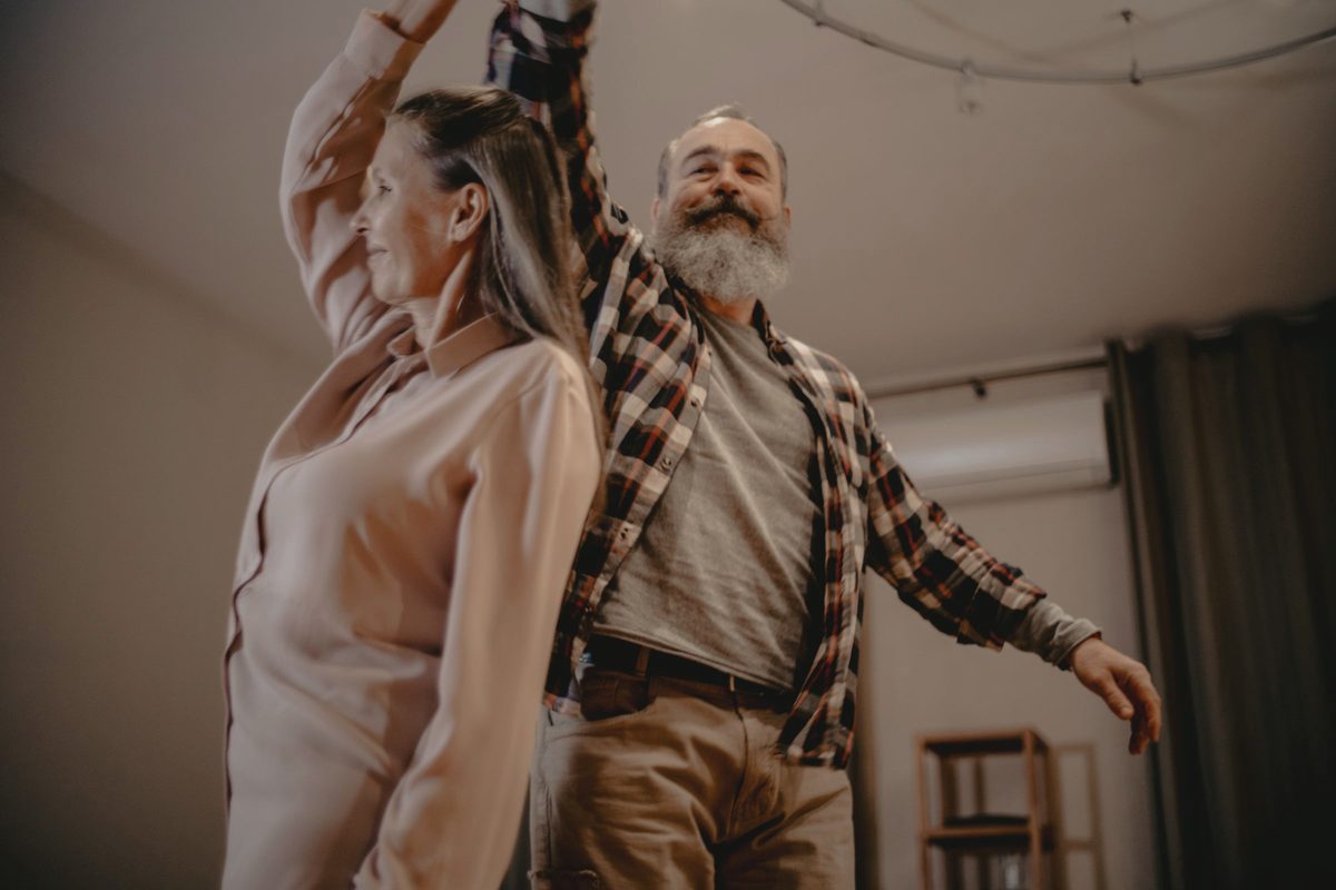 An elderly couple dancing in a living room