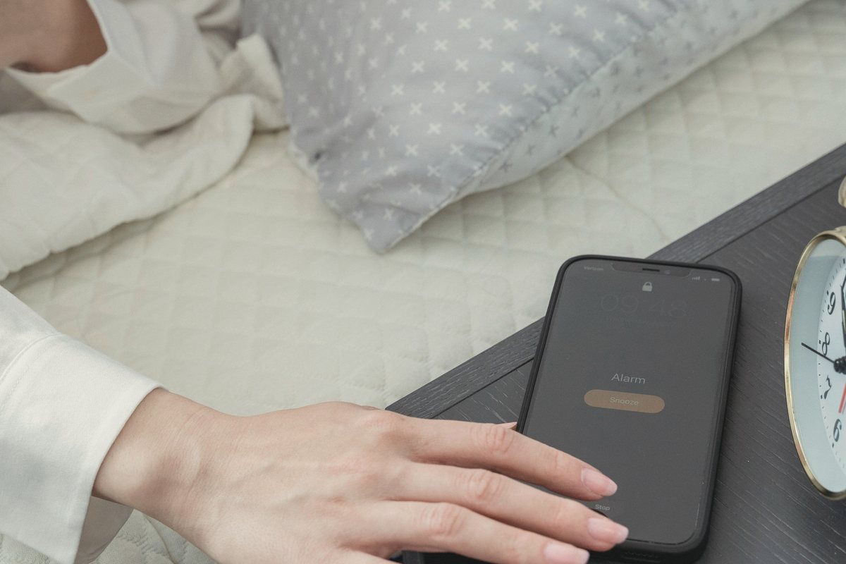 Person placing a phone on the bedside table as part of an evening wind down routine