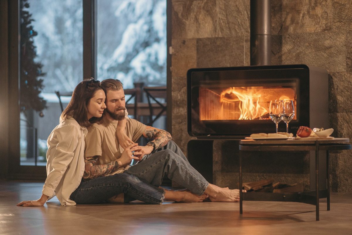 Man and woman sitting on floor near fireplace
