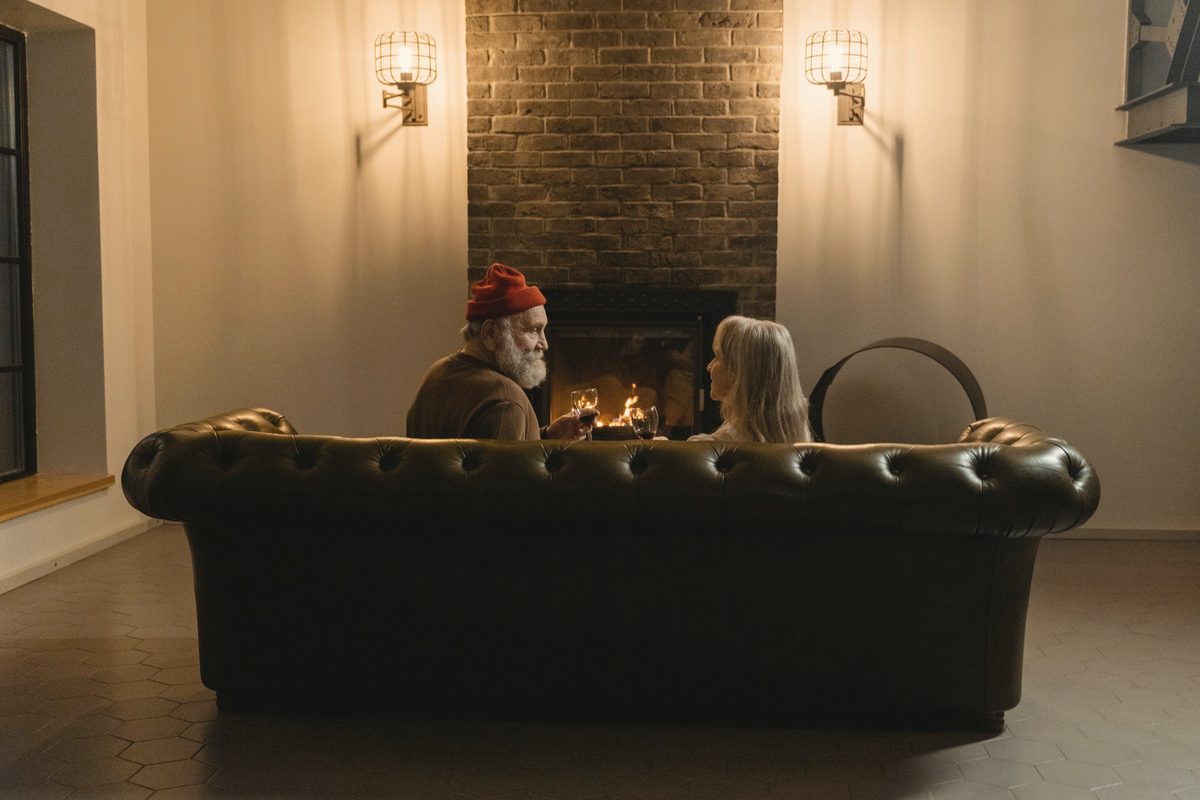 People sitting on a couch in front of a fireplace