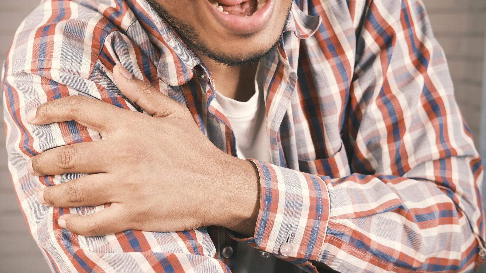 Man holding his sore shoulder