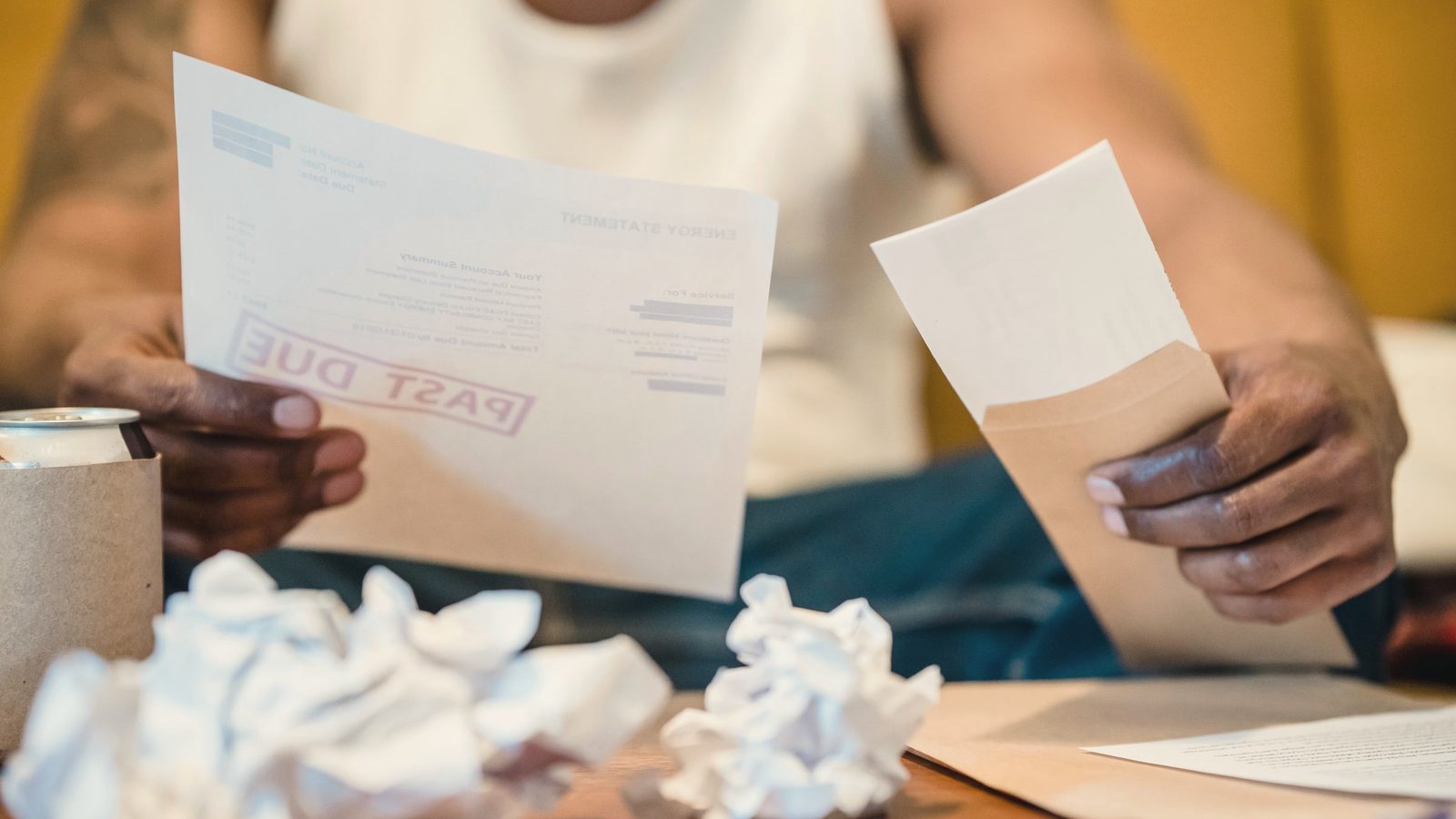 Man looking anxiously at paperwork at home