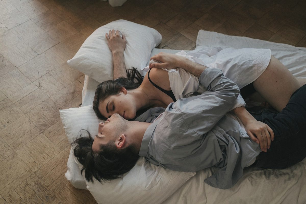 Couple asleep together on white bedding