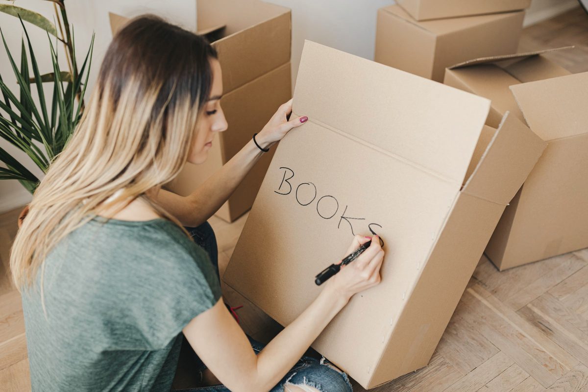 Woman writing on a cardboard box