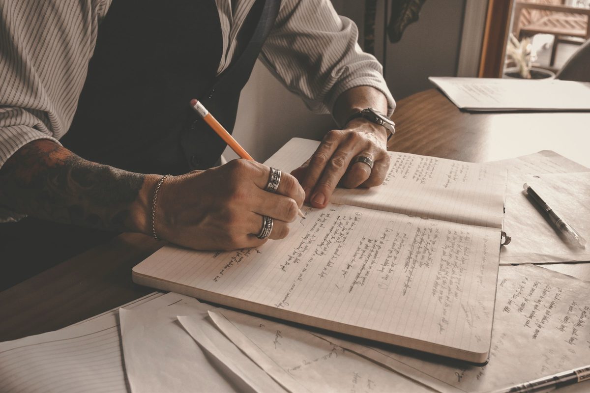 A person writing on a notebook
