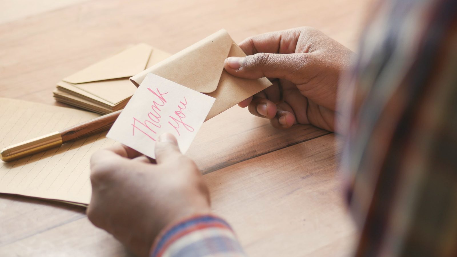 Hands holding a thank-you note and envelope
