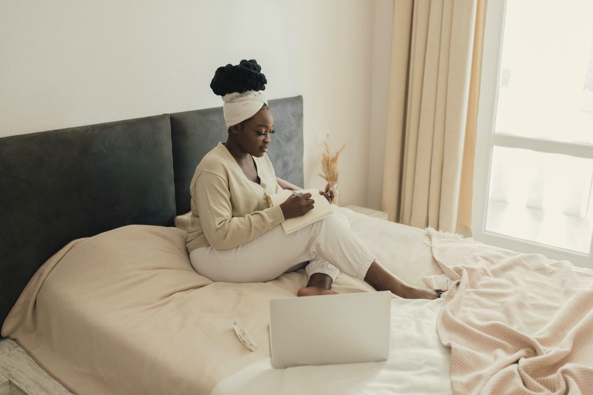 Woman writing in her journal in bed