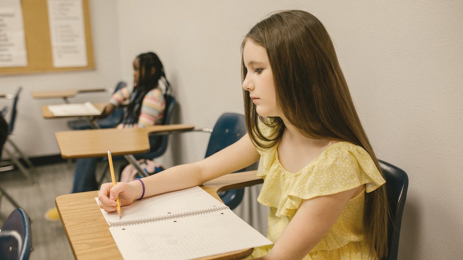 Girl writing in her notebook at a desk
