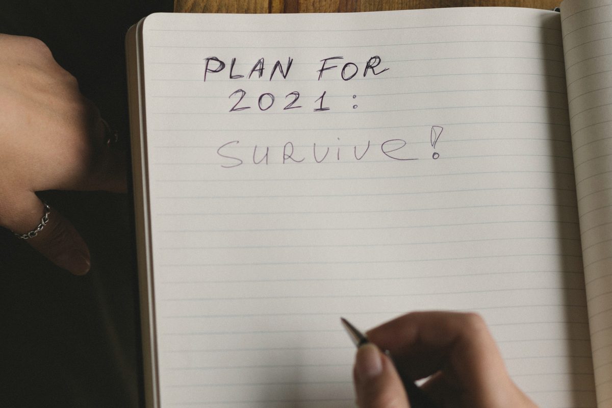 Woman writing plans in diary sitting at table