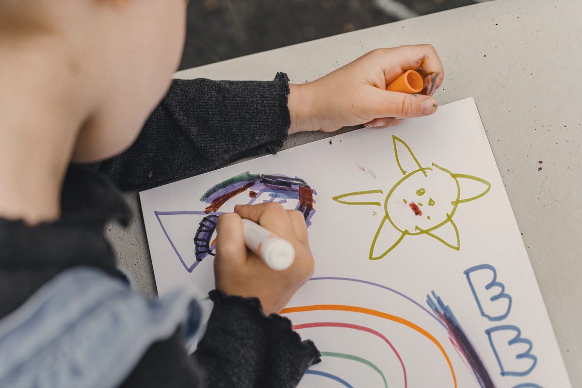 Child drawing on sheet of paper
