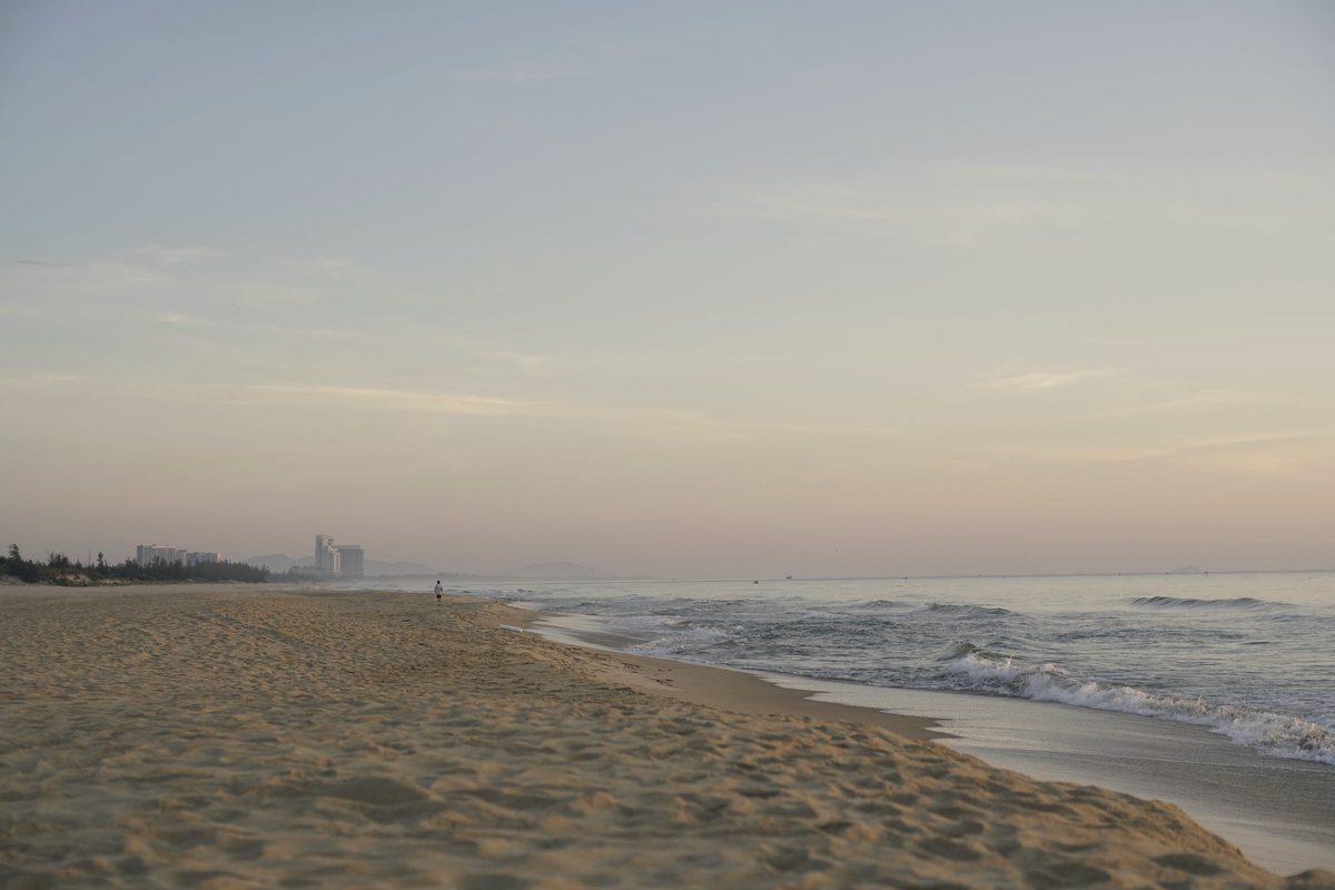 Person walking along the beach at dusk