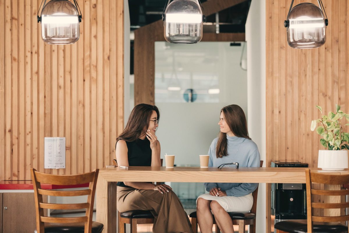 Friends chatting over coffee at a cafe table