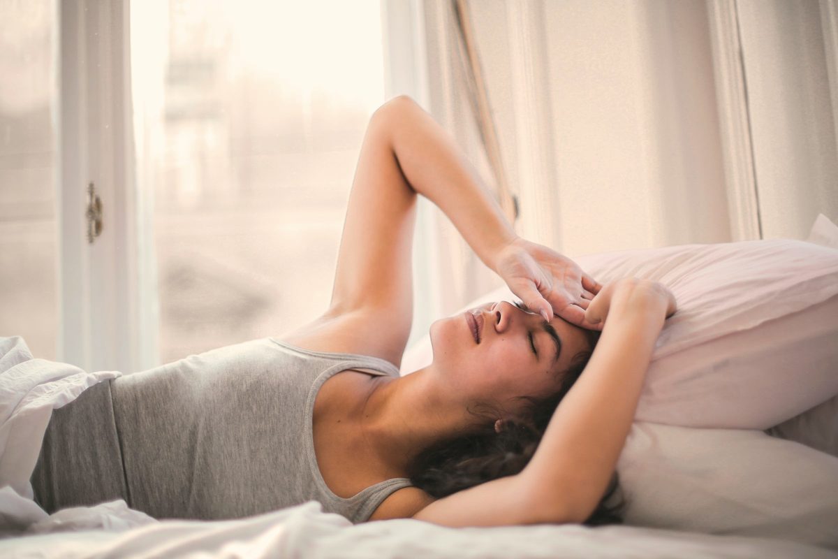 Woman drifting off on her bed