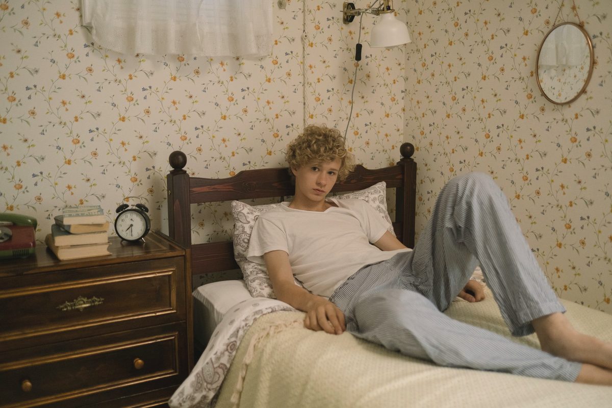 Young man lying on his bed in a quiet room