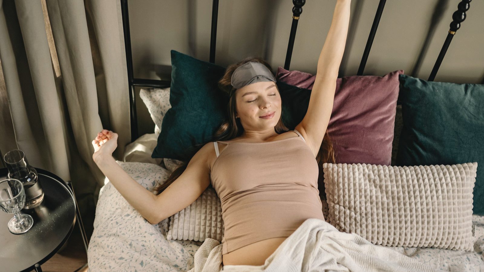 Woman stretching her arms while lying in bed