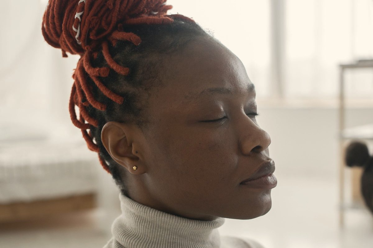 Calm woman meditating with closed eyes at home