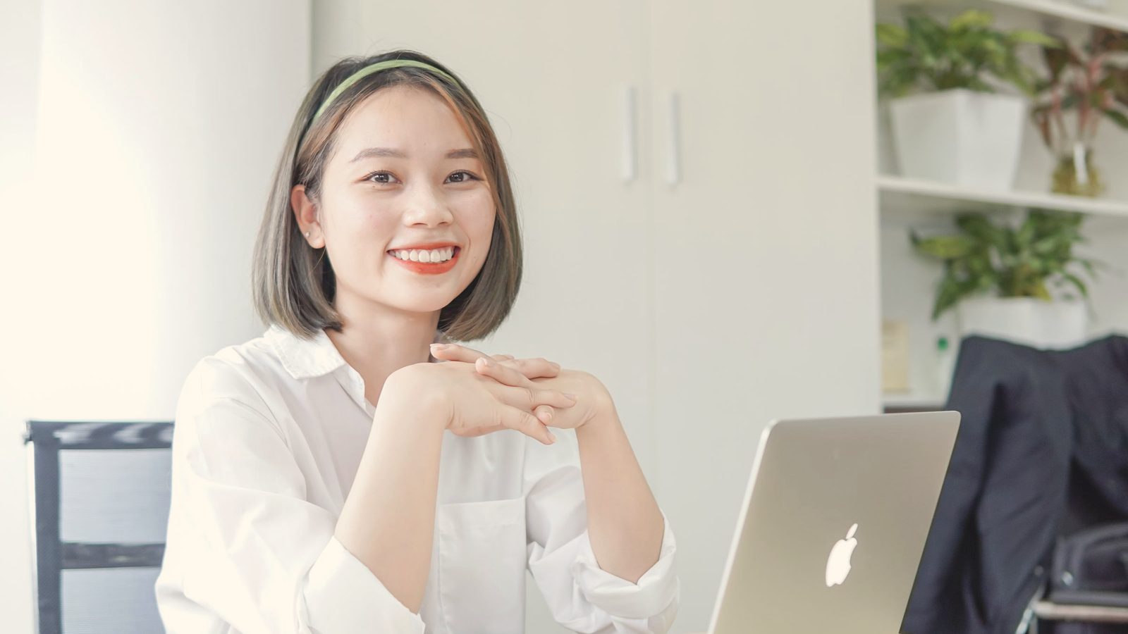 Smiling woman sitting at desk with laptop