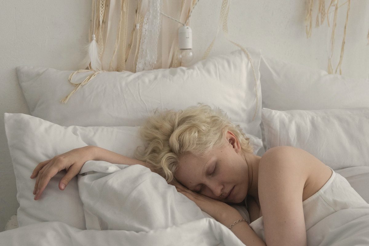 Sleepy woman resting on bed in morning
