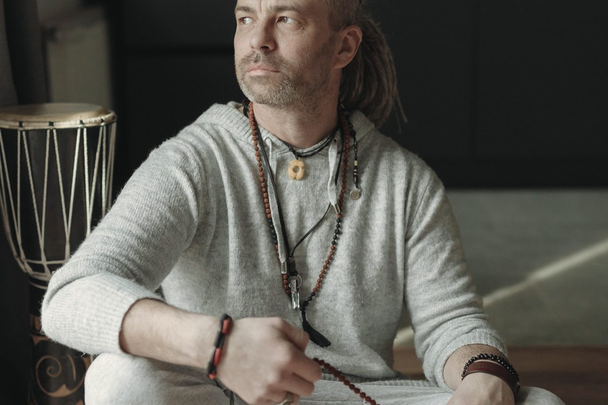 Man sitting cross-legged holding prayer beads