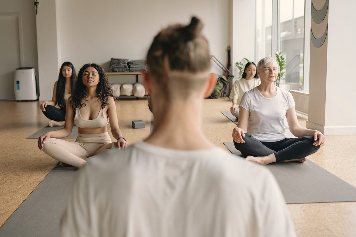 Selective focus of people meditating in a yoga class