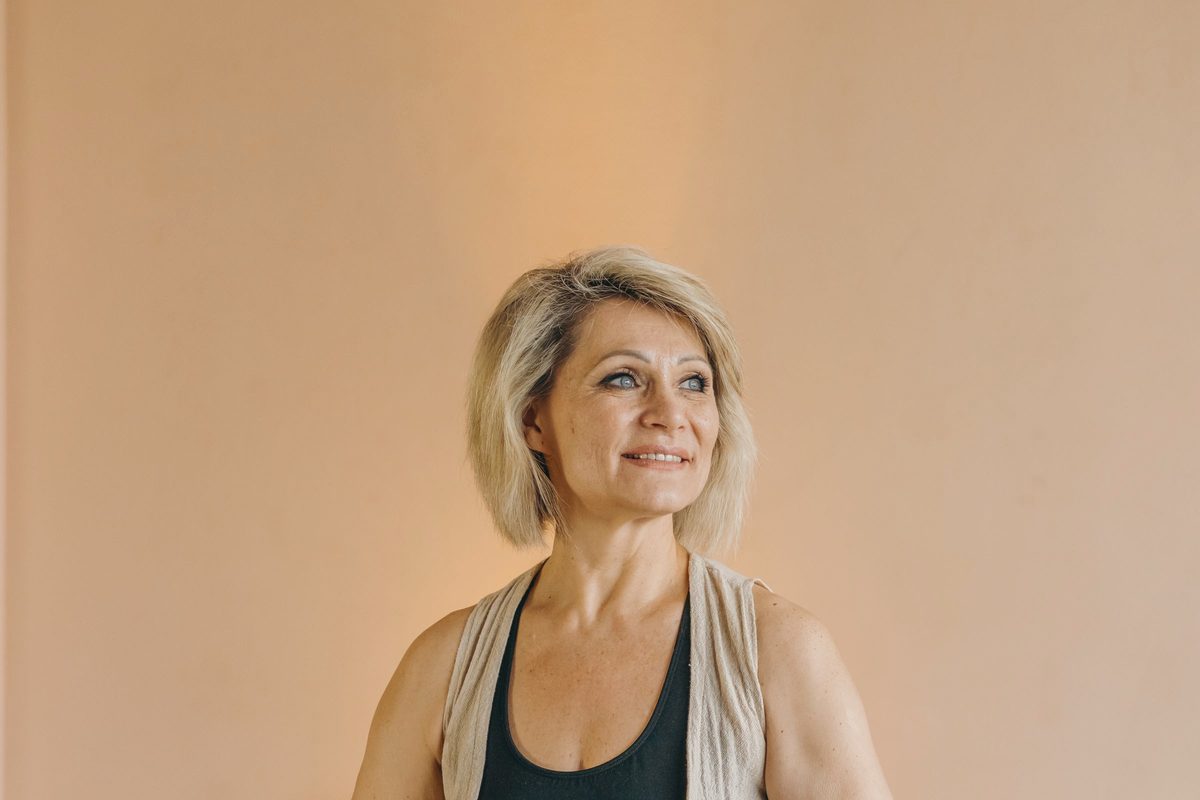 Older woman sitting cross-legged on a mat