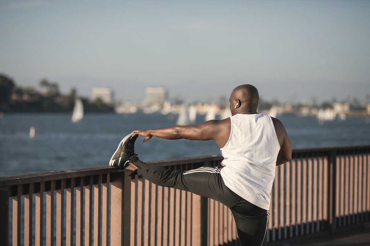 Man doing a slow stretch by the water