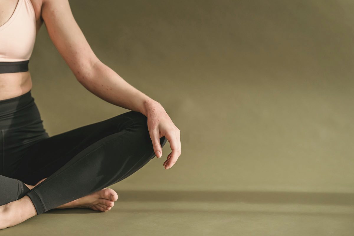Woman sitting in a cross-legged pose with her hands on her knees