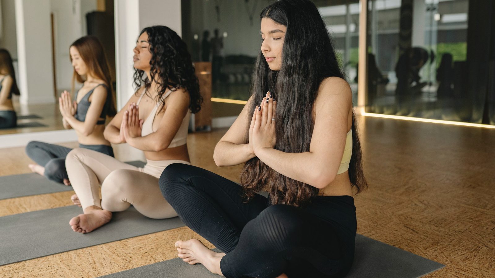 Women sitting with their palms together in a group class