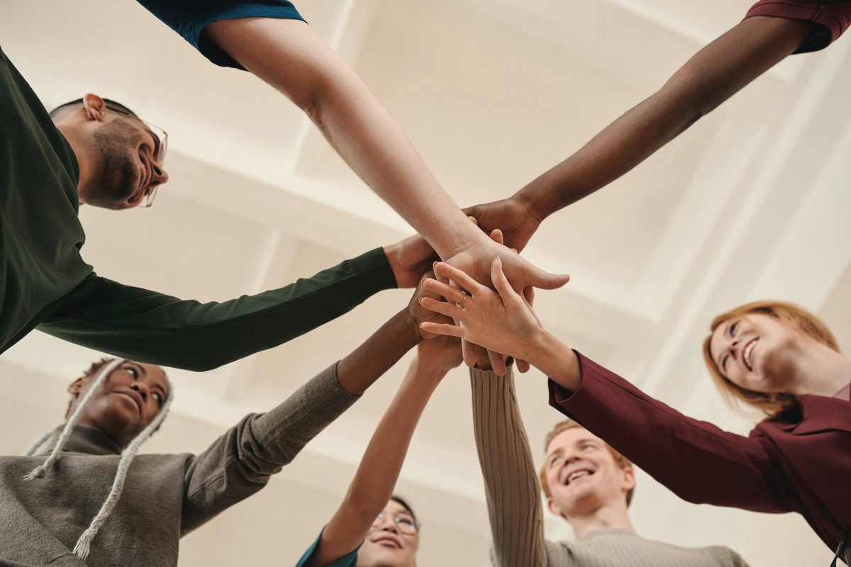Friends putting their hands together in support