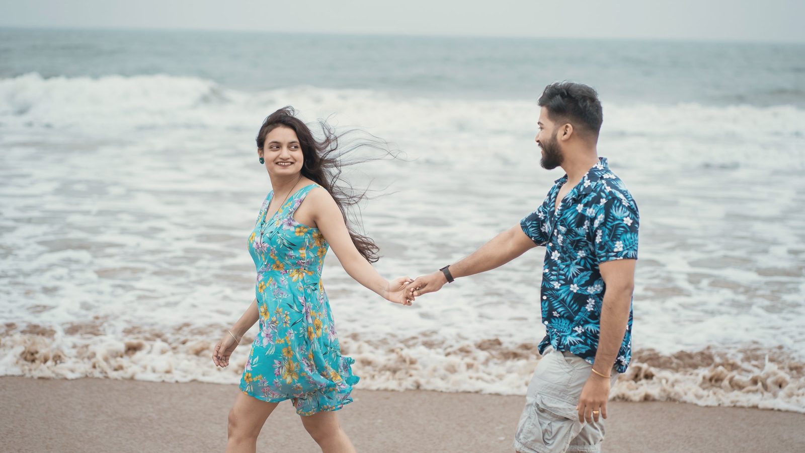 Smiling couple holding hands on the beach