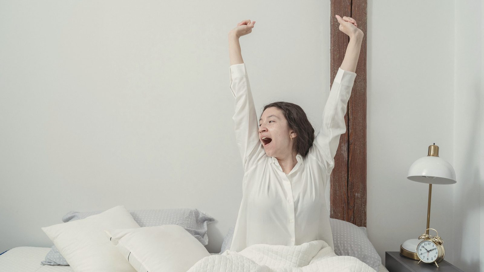 Young woman awakening in bed in morning
