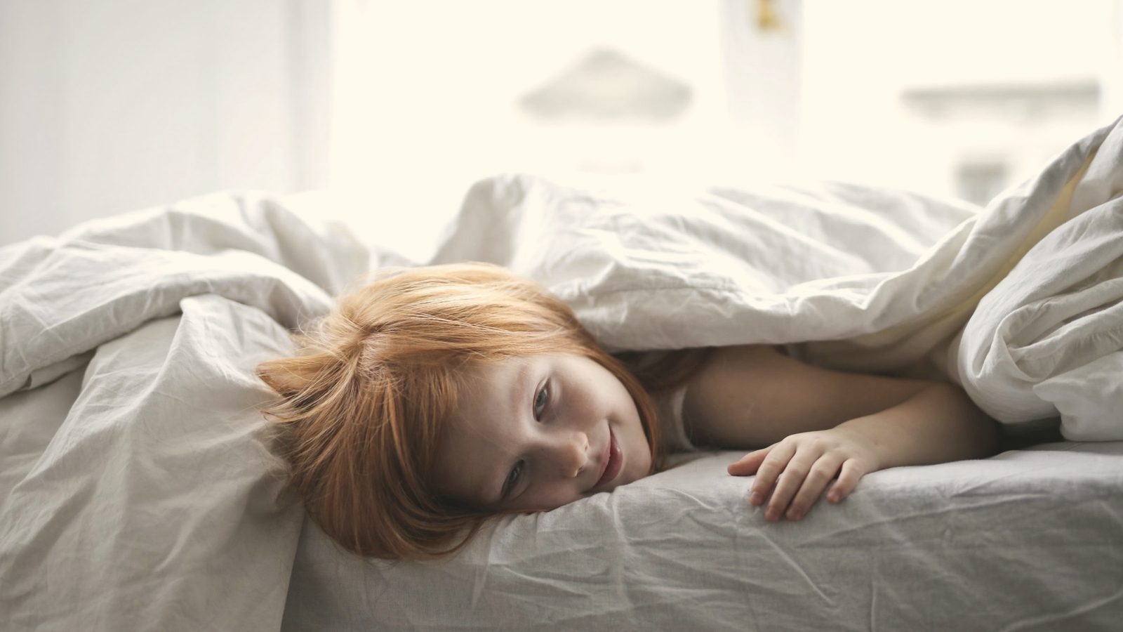 Child sleeping under a blanket