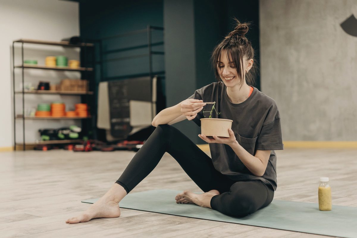 Woman enjoying a meal on her living room floor after exercise