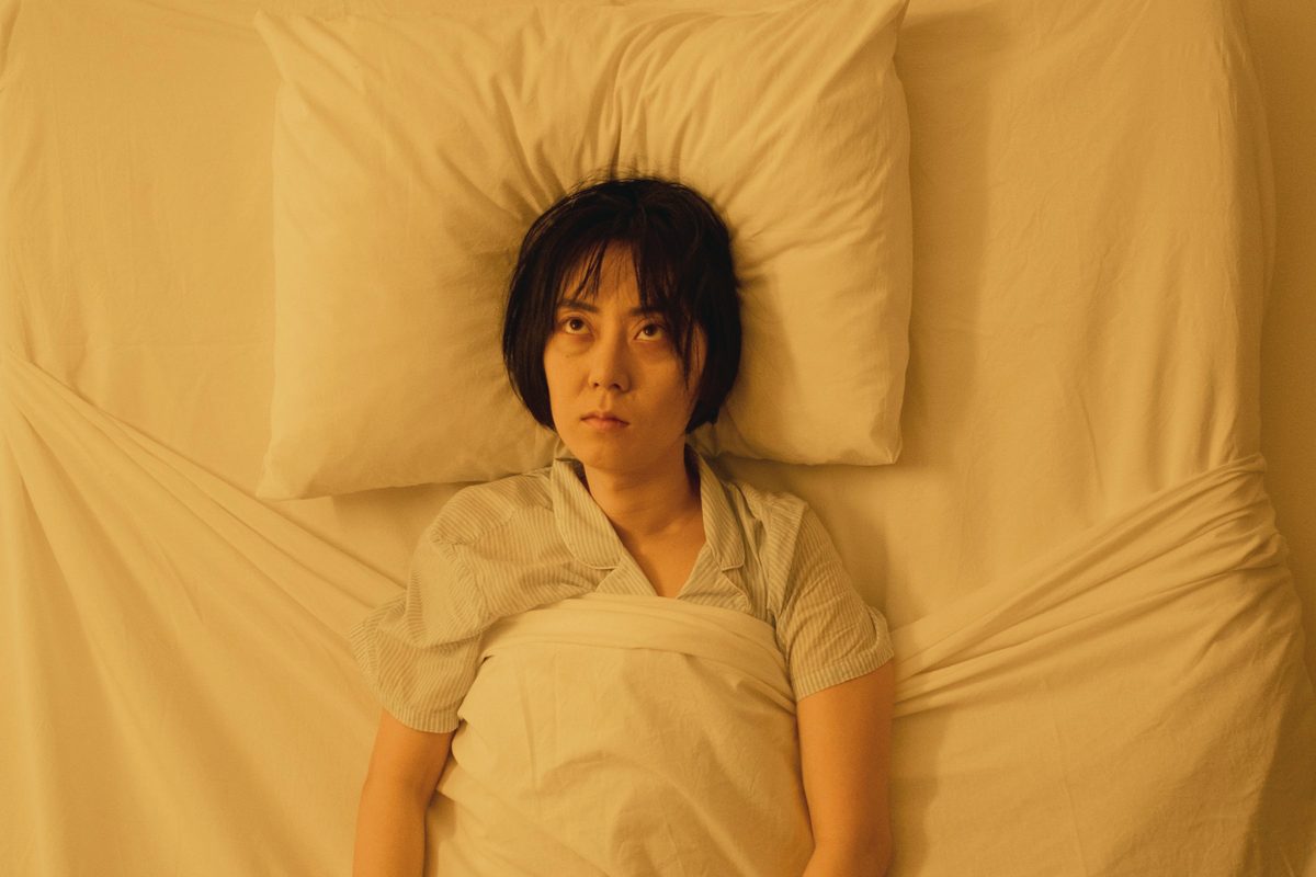 A woman wide awake while lying on the bed