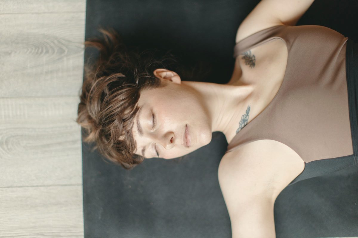 Woman lying on a mat with her eyes closed