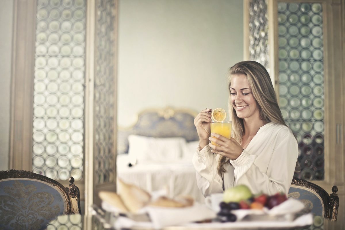 Cheerful woman enjoying breakfast in morning
