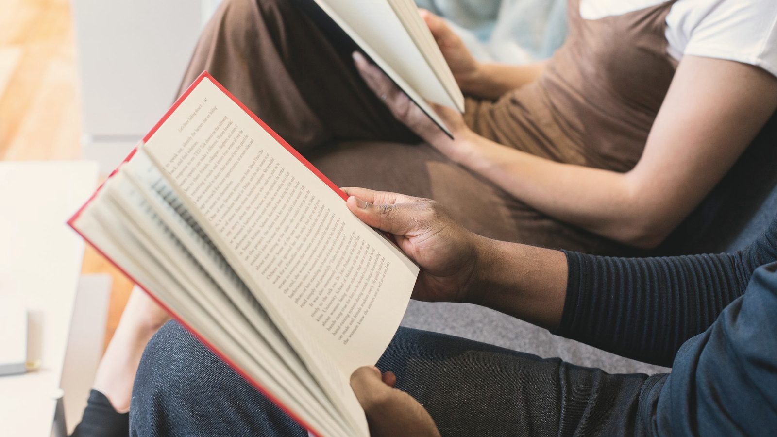 Two people reading books side by side