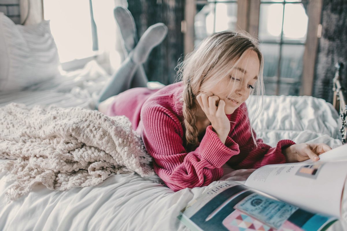 Woman reading book on bed