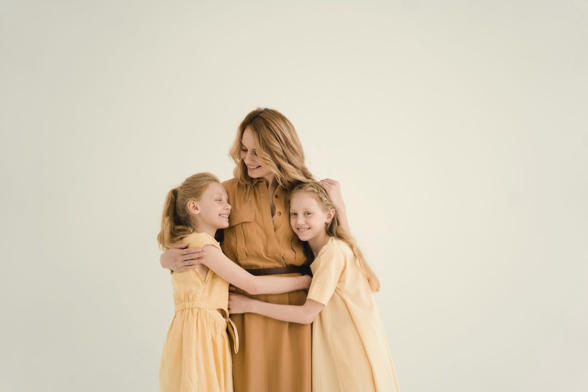 A mother and two children hugging each other